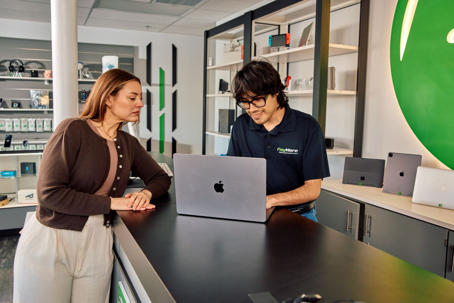 paymore employee inspecting a laptop